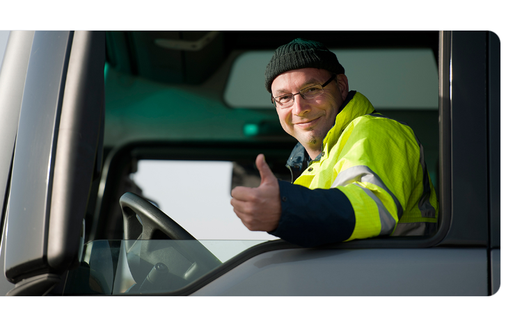 Smiling truck driver giving a thumbs up from the cab